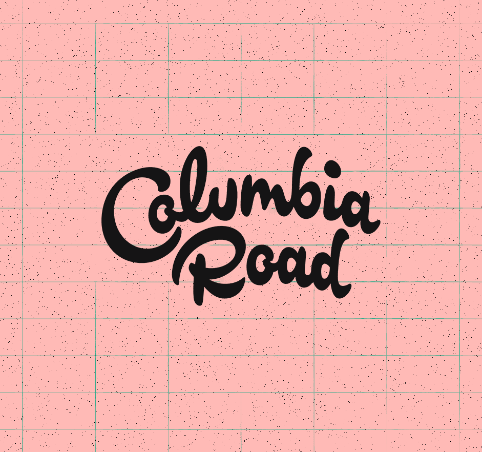 Black "Columbia Road" script text on pink grid background with speckled texture.